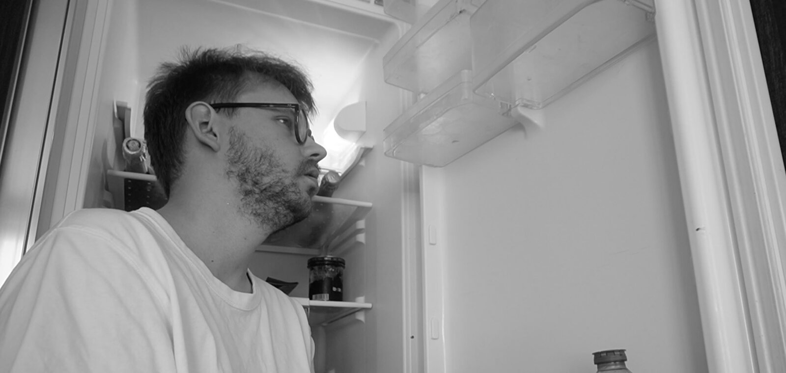 Submission Canicule still — the protagonist stares into a fridge, black and white
