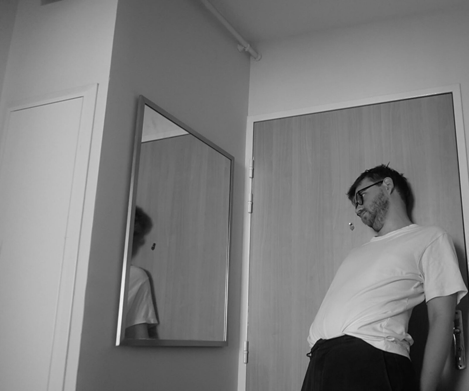 Submission Canicule still — a mirror reflection in a hallway, black and white