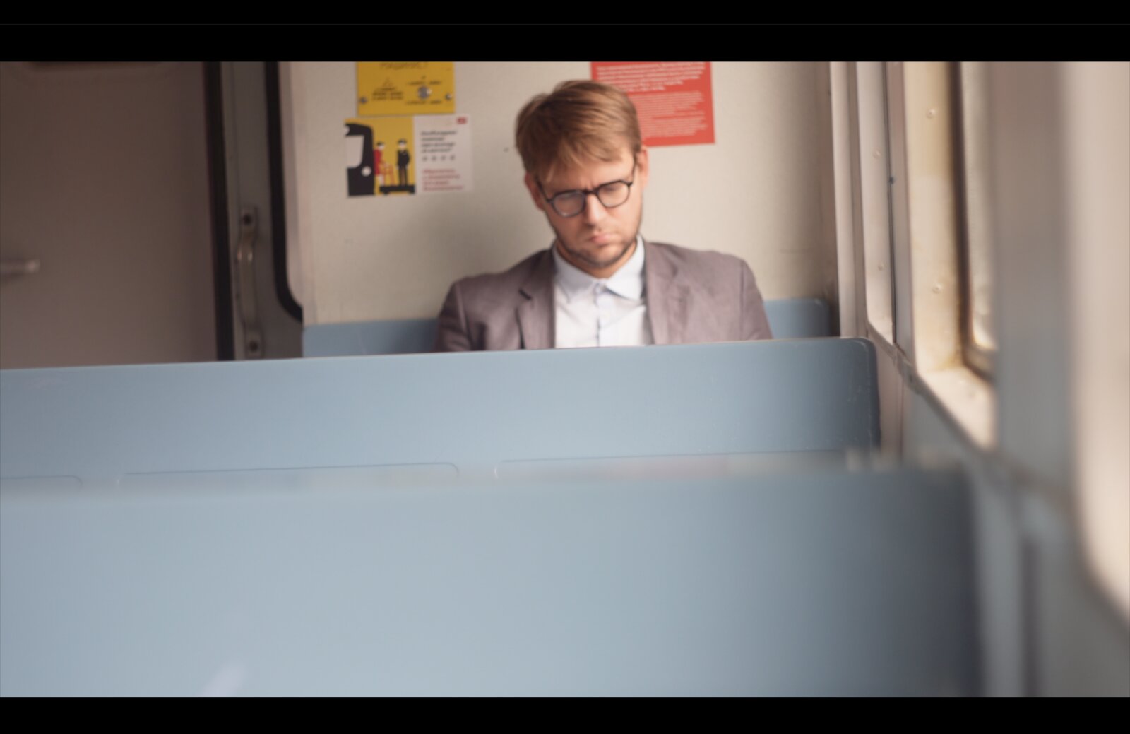 Future Days still — a man in a train compartment, seen past a folded-down bunk