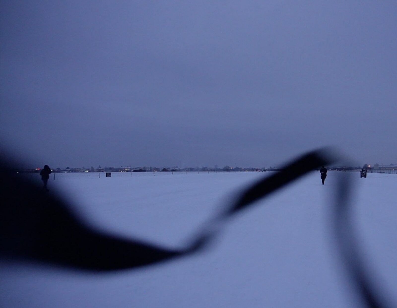 Getting Lost still — snow field in Berlin, a silhouetted shape in the foreground